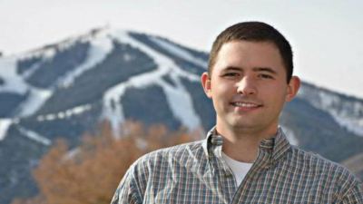 Man in photo with mountains behind him. 
