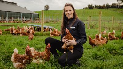 Alltech employee holding chicken in field